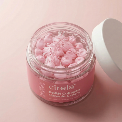 A glass jar of Cirela Beauty PDRN Collagen Capsule Cream with a white lid holds pink capsules on a pink surface. The open jar reveals neatly arranged capsules that promise an instant glow.