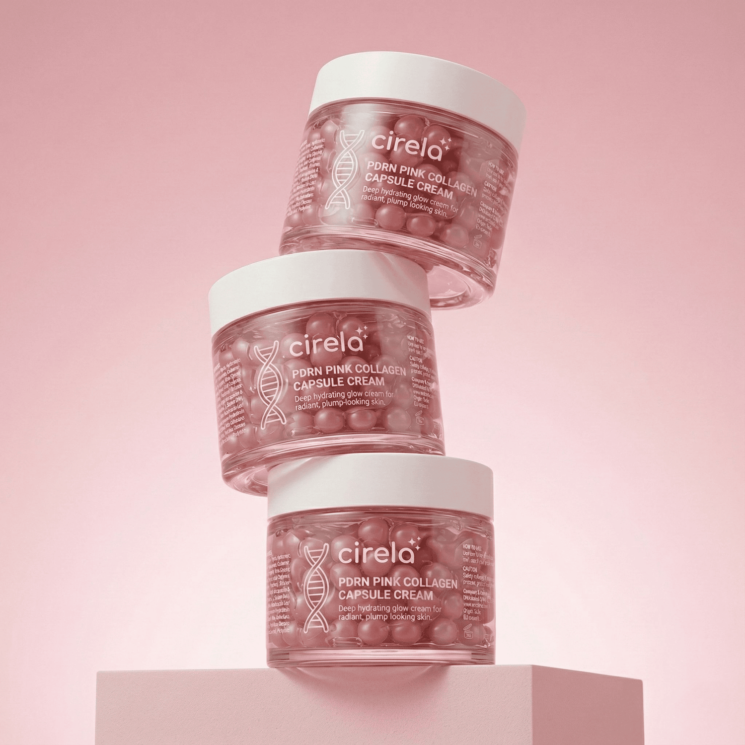 Three clear jars of Cirela Porn Pink Collagen Capsule Cream are stacked against a pink gradient background. The jars contain pink capsules and display white product labels with text and a DNA helix graphic.