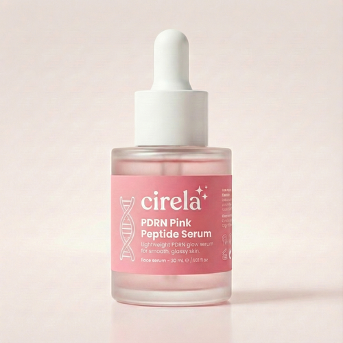A clear dropper bottle of Cirela Beauty’s PDRN Pink Peptide Serum with pink liquid sits on a light background. The label shows a DNA helix graphic and skincare details.