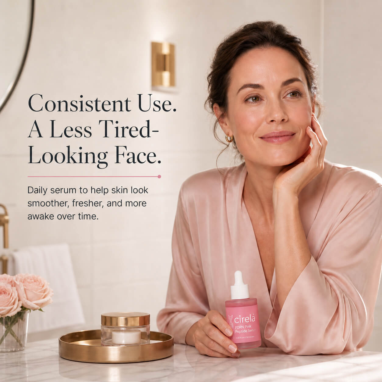A woman in a pink robe smiles in a bathroom while holding a pink bottle of Cirela daily serum. Text reads: Consistent use. A less tired-looking face. Skincare products sit on the counter nearby.